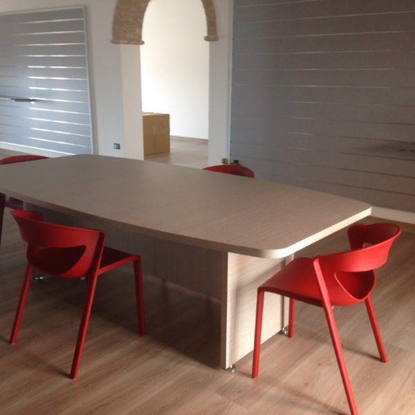 Arredamento showroom tavolo e sedie kicca rosse - Riganelli Arredamenti