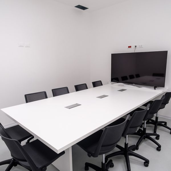 Sala riunione con tavolo sedute e monitor - riganelli