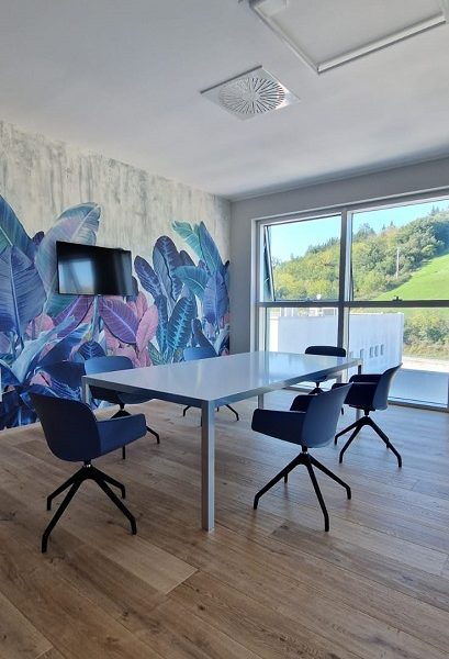 Sala riunioni con tavolo bianco e sedie blu -riganelli